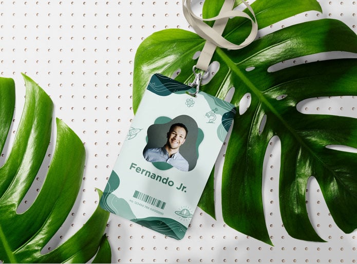 Our tear proof eco friendly synthetic event badges on a white peg board background and large palms