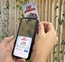 Person scanning a Lost Americana NFC card with a smartphone to access exclusive digital content.