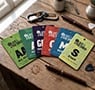 Color-coded event badges for all-access, VIP, general admission, crew, media, and staff, displayed on a wooden table.