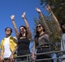 Group of friends showing colorful RFID event wristbands at a festival
