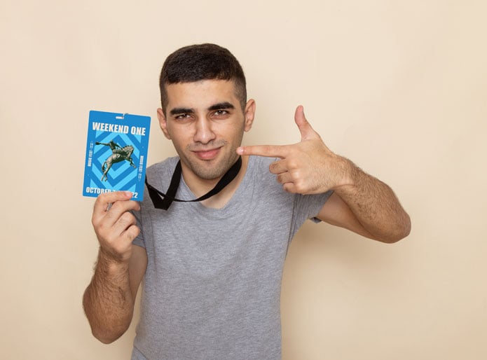 man holding a RFID event badge for Austin city limits music festival looking pleased 