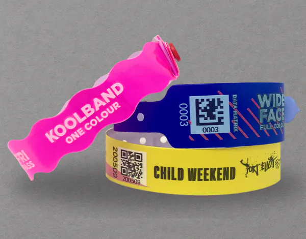 Assorted vinyl wristbands in pink, blue, and yellow with barcodes, holographic stickers, and printed security text, designed for multi-day tamper-proof use