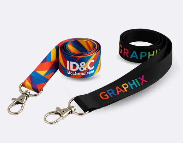 Two satin polyester lanyards with premium finishes, one in multicolour with ID&C branding and one black with &ldquo;GRAPHIX&rdquo; text, featuring metal clips and smooth, high-end appearance
