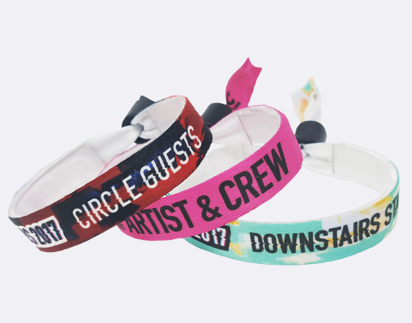 Three woven fabric wristbands with text like &ldquo;CIRCLE GUESTS&rdquo; and &ldquo;ARTIST & CREW,&rdquo; showcasing premium wristbands for festivals or VIP events in the UK