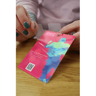 Person holding an antibacterial laminated festival pass designed to reduce bacterial transmission